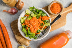 bowl of lettuce topped with carrot ginger dressing