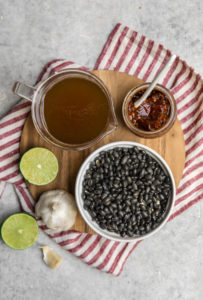 ingredients for chipotle garlic black beans on wood cutting board