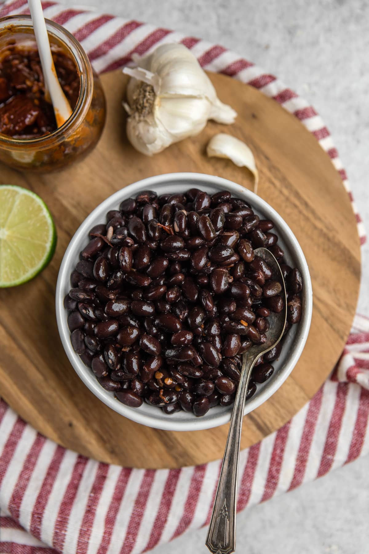 bowl of chipotle garlic black beans on wood cutting board