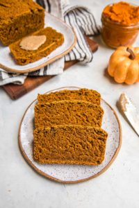 slices of vegan pumpkin bread on white plate with white background