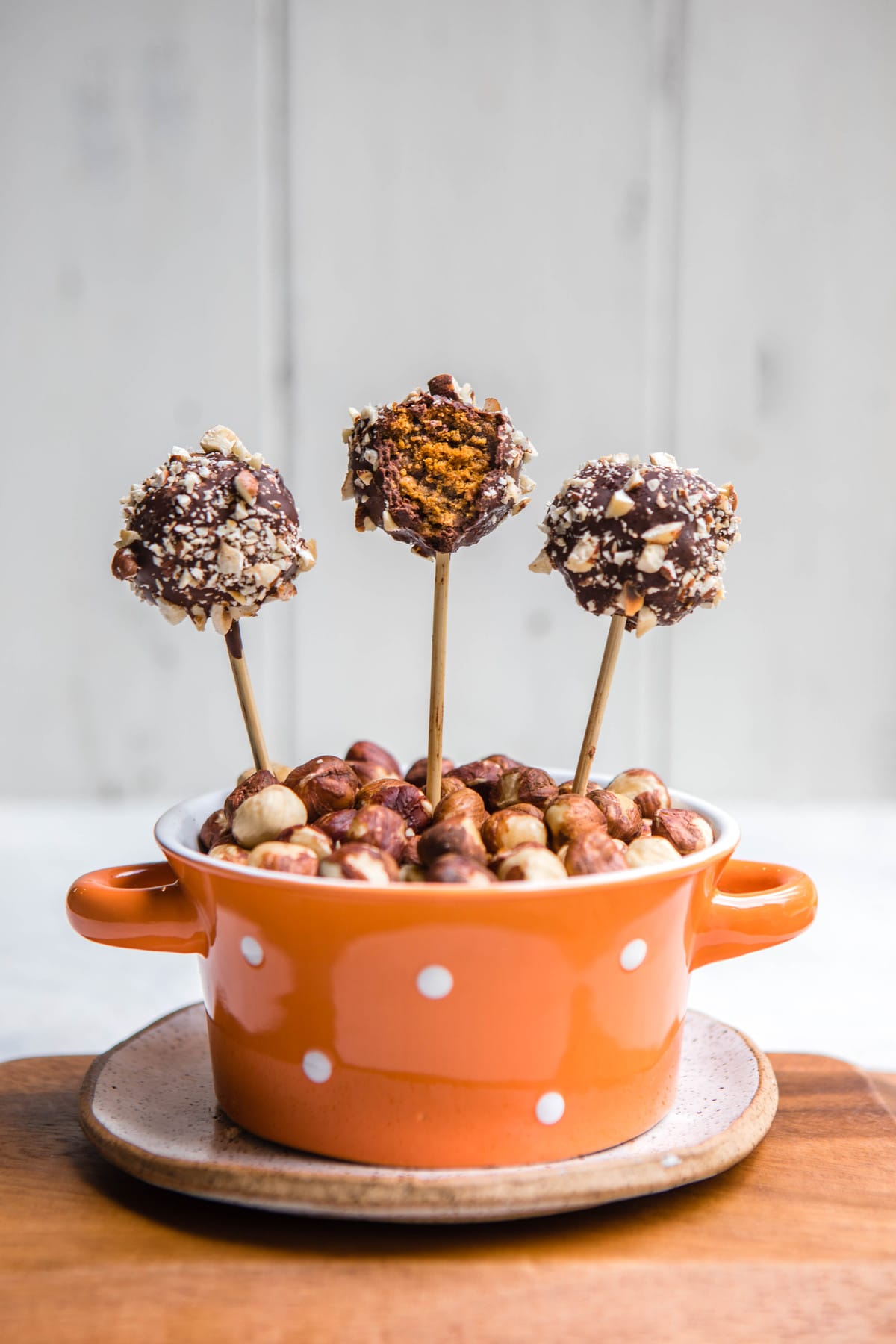chocolate covered pumpkin spice cake pops in orange spotted bowl
