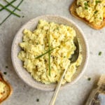 vegan egg salad in large white bowl with fresh chives and black pepper