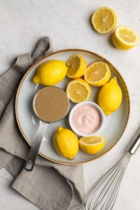 ingredients for lemon tahini dressing on white serving board