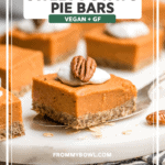 Sweet potato pie bars topped with coconut cream and pecan on marble serving tray