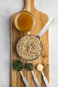 ingredients for rosemary garlic lentils on wood cutting board