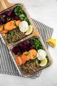 glass tupperwares filled with warm lentil salad ingredients for meal prep