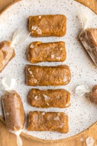 healthy salted caramel bites in row on white speckled plate