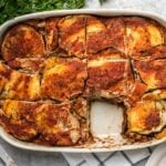 large white casserole dish of baked eggplant lasagna with one slice taken out