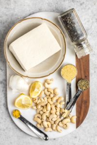 ingredients for vegan ricotta cheese on white cutting board