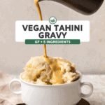 Hand pouring tahini gravy over pile of mashed potatoes in white bowl