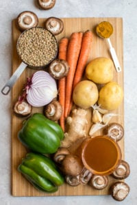 ingredients for curried lentil soup on wooden cutting board