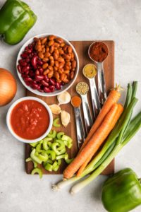 ingredients for vegan chili on wooden cutting board