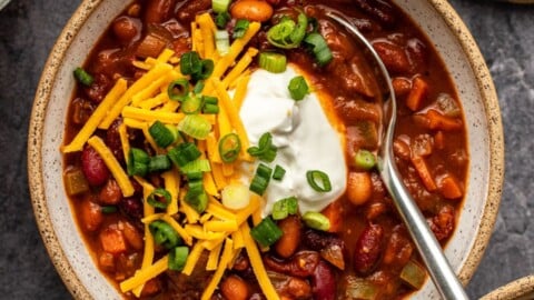 Bowl of bean chili topped with sour cream and green onion