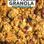 Overhead close-up photo of golden baked granola topped with fresh cranberries