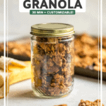 Golden baked vegan granola in glass har with baking sheet of granola in the background