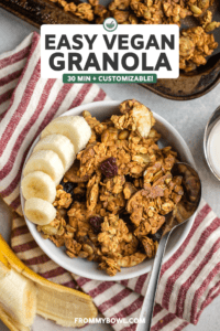small white bowl of vegan granola with fresh banana slices and silver spoon