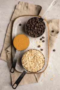 ingredients for no-bake peanut butter cookies on white speckled serving platter