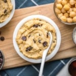 white bowl filled with chocolate chip chickpea cookie dough on wooden serving tray