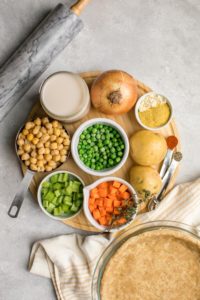 ingredients for chickpea pot pie arranged on circular wood cutting board