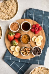 ingredient options for customizable steel cut oatmeal on round wood cutting board