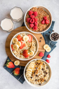 three white bowls of steel cut oatmeal topped with various toppings
