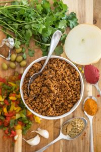 ingredients for vegan picadillo on wooden cutting board