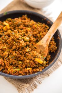 black skillet with cooked vegan picadillo and wooden spoon