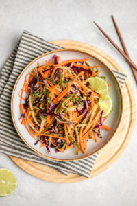 white bowl filled with cruchy asian slaw and wooden chopsticks