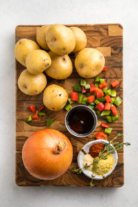 ingredients for vegan breakfast potatoes on wood cutting board