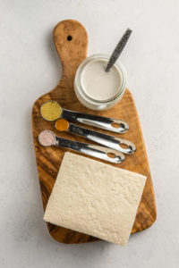 ingredients for tofu scramble on small wooden cutting board