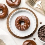 chocolate covered chocolate donuts arranged on white background with bowl of chocolate chips