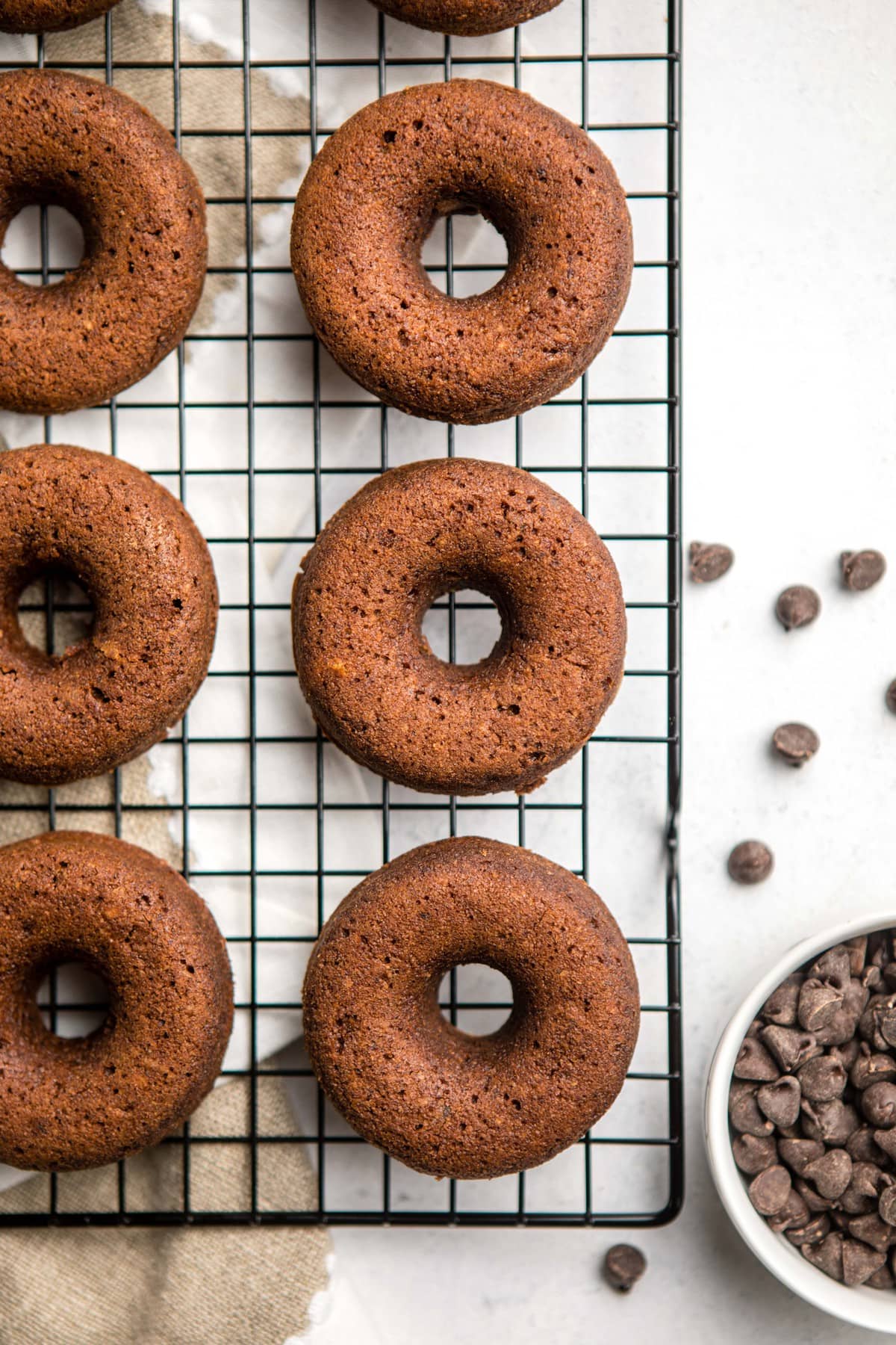 baked chocolate donuts on black wire cooling rack