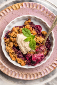 berry crumble with coconut yogurt and fork with bite on it