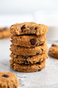 stack of banana almond pulp cookies with bite taken out of top cookie