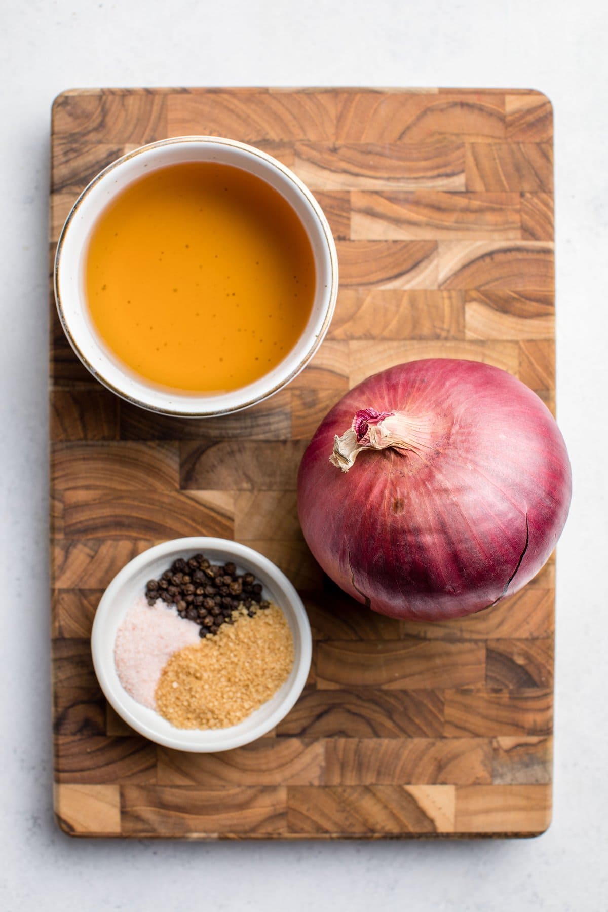ingredients for pickled red onions on wood cutting board