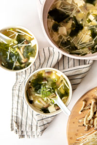large pot of miso soup with two white small bowls