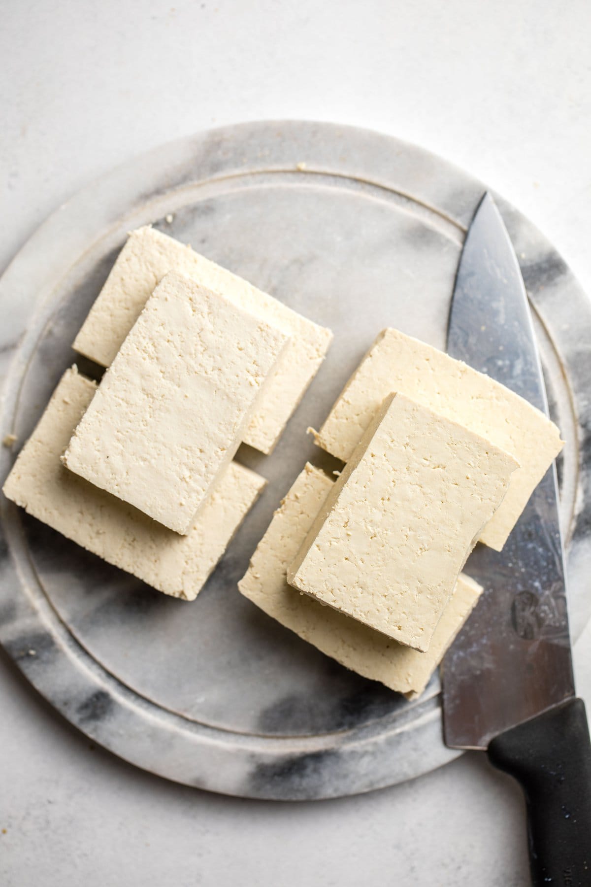 cut tofu blocks on round marble cutting board