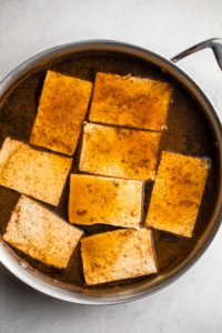 tofu in large grey pot covered in marinade