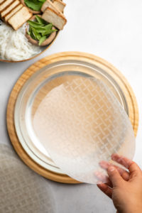 hard rice paper over bowl of warm water