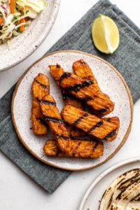 grilled bbq tempeh on white plate with napkin