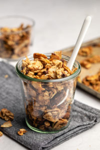 jar of small batch granola with baking tray in the background