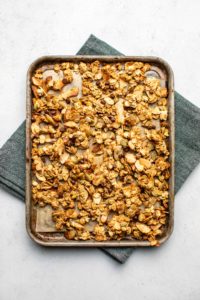 cooked small batch granola on small baking tray over navy napkin