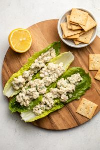 tempeh tuna salad in lettuce boats with crackers and lemon wedge on the side
