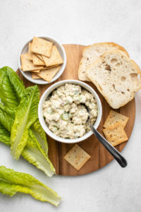 serving suggestions for tempeh tuna salad on round wood cutting board