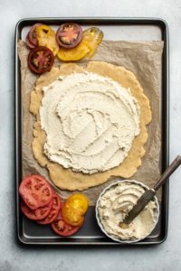 lined baking tray with galette crust and ricotta spread over it