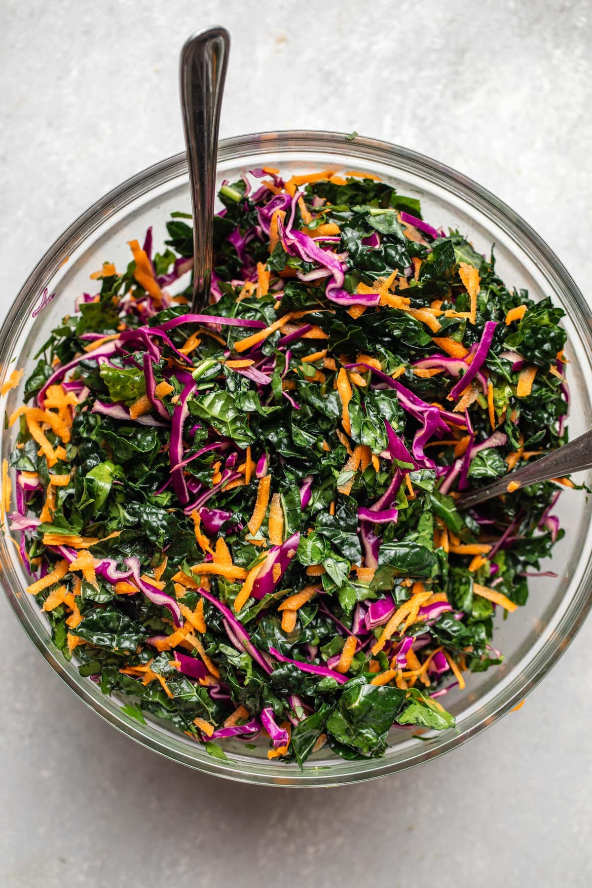 kale, cabbage, and carrot in large glass mixing bowl