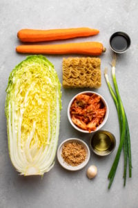 ingredients for kimchi noodle salad on grey stone board