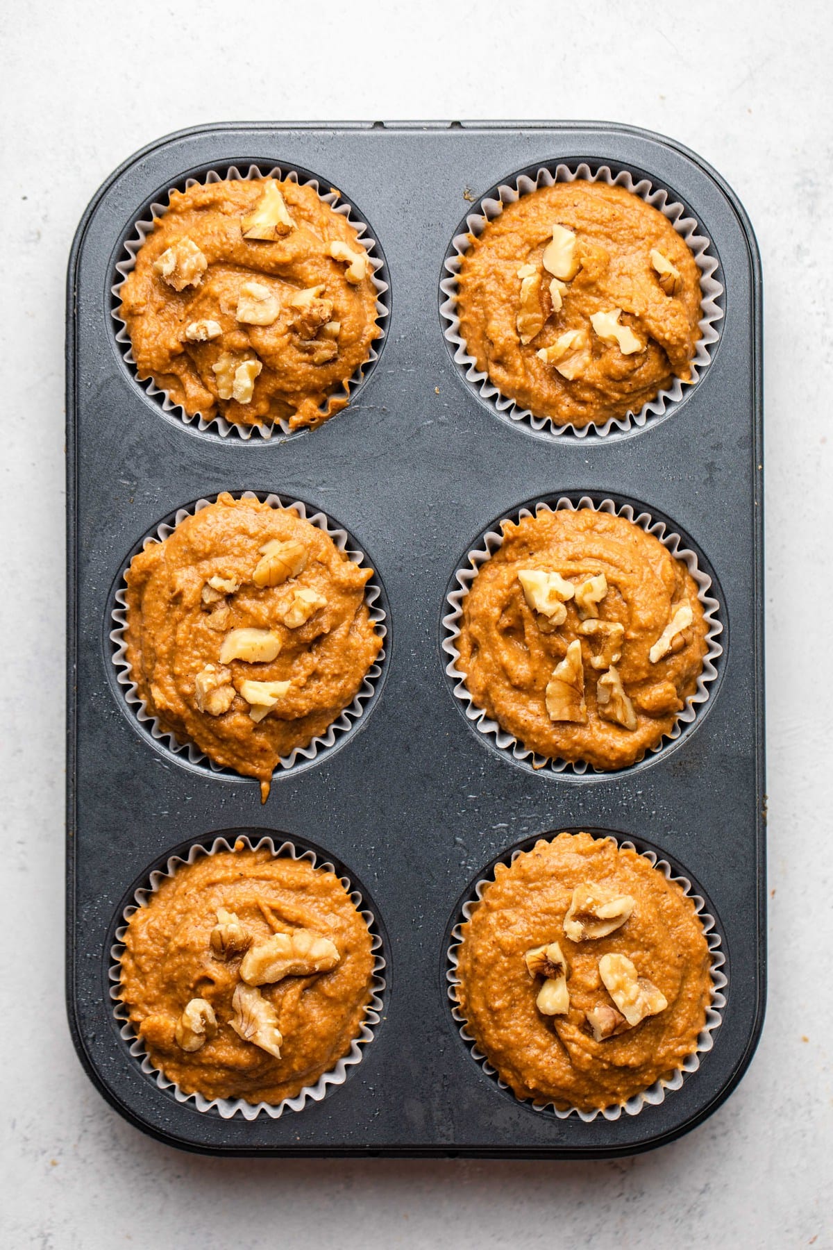 unbaked pumpkin muffins in muffin tin