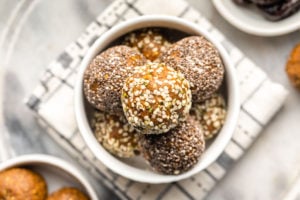 sugar free golden milk energy bites rolled in hemp and chia seeds in white bowl