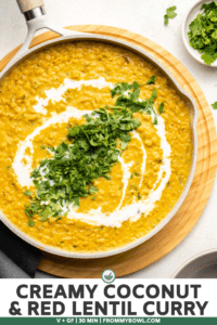 large white pot of red lentil curry topped with coconut milk and cilantro